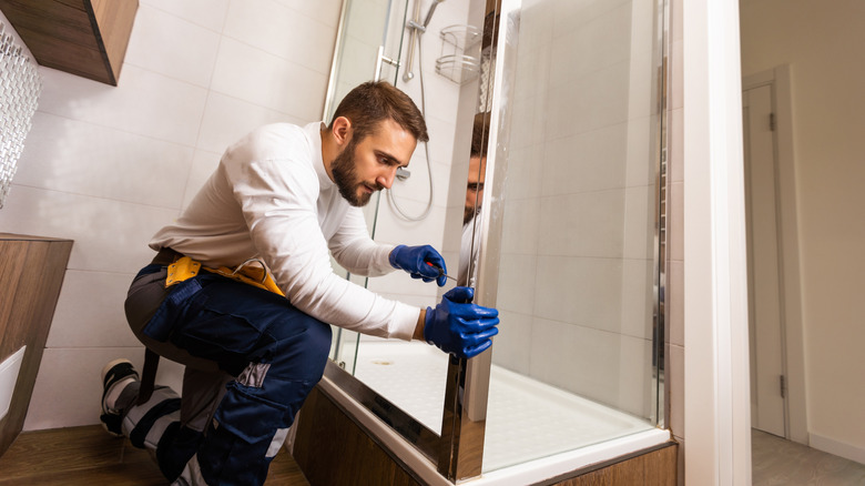 A worker installing a new shower in a bathroom