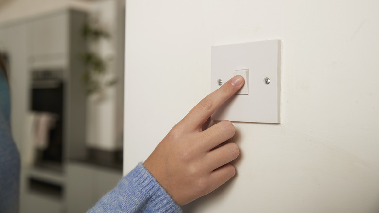 A person flipping a light switch