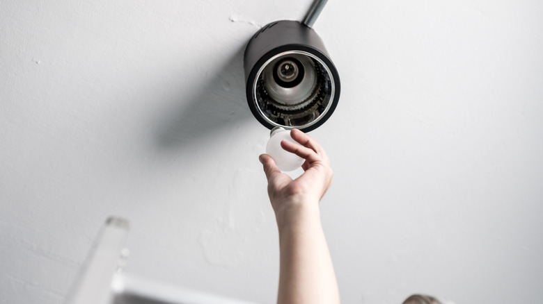 A person changing a light bulb