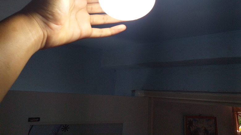 A person touching a bright light bulb