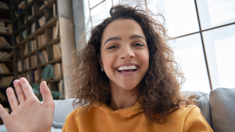 woman smiling and waving