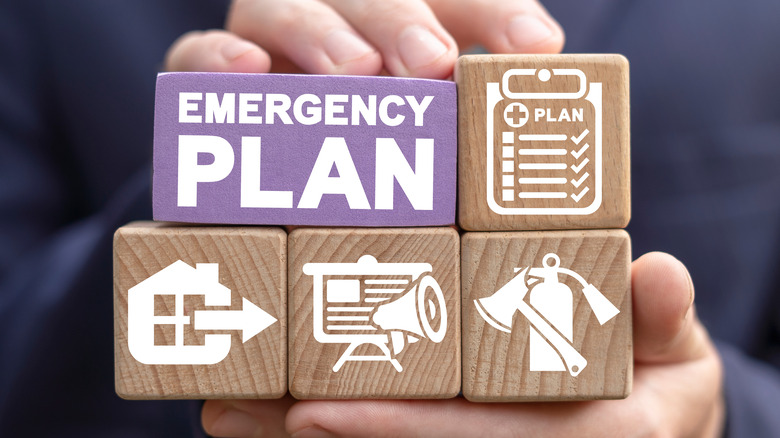 person holding emergency plan blocks