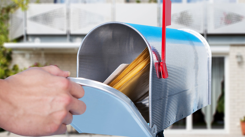 person checking mailbox with letters