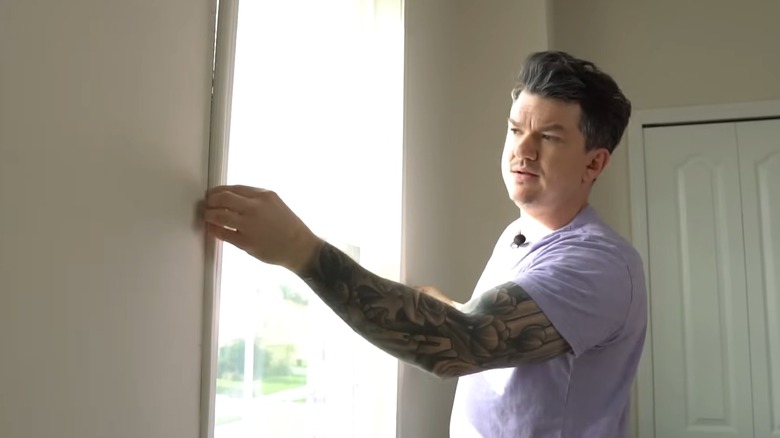 Man installing a window insert over a window