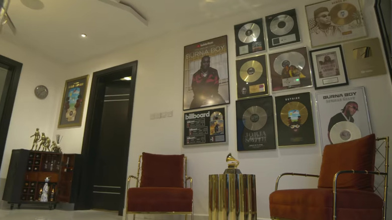 Burna poses against wall of awards