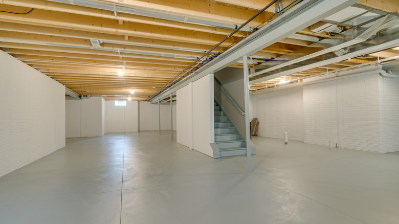 an empty unfinished basement with staircase