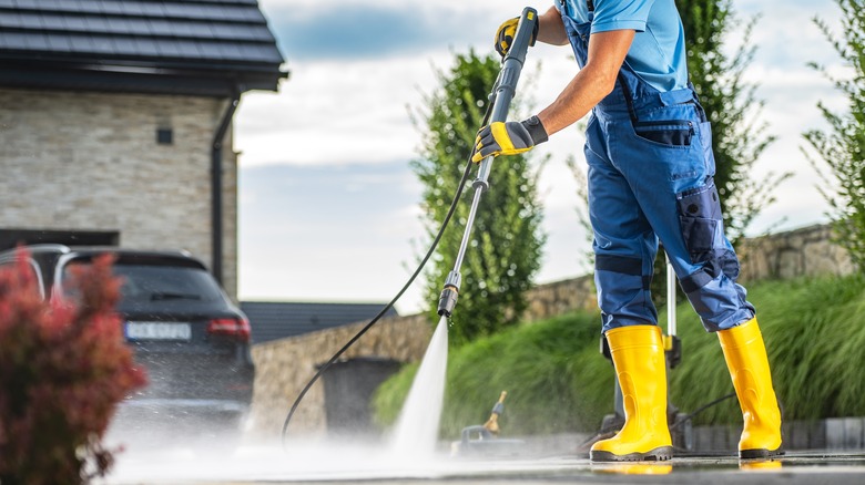 person pressure washing driveway