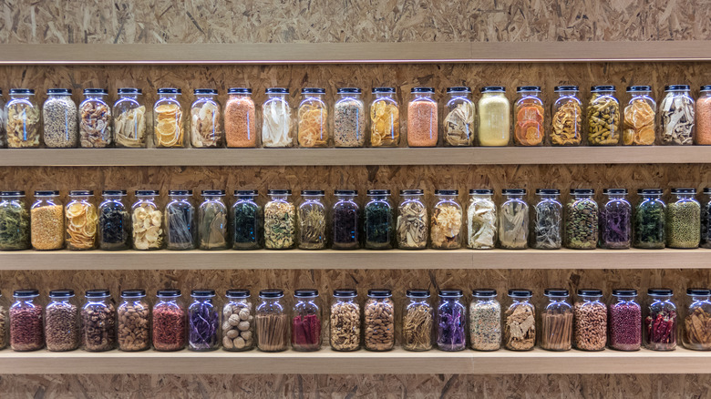 Rainbow of items stored in mason jars on shelves