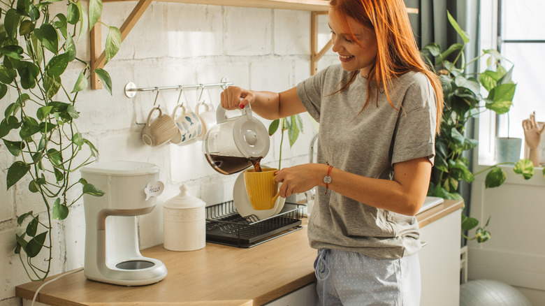 Someone pouring coffee into a mug