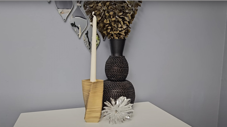 A gold DIY taper candle holder sits next to a decorative vase