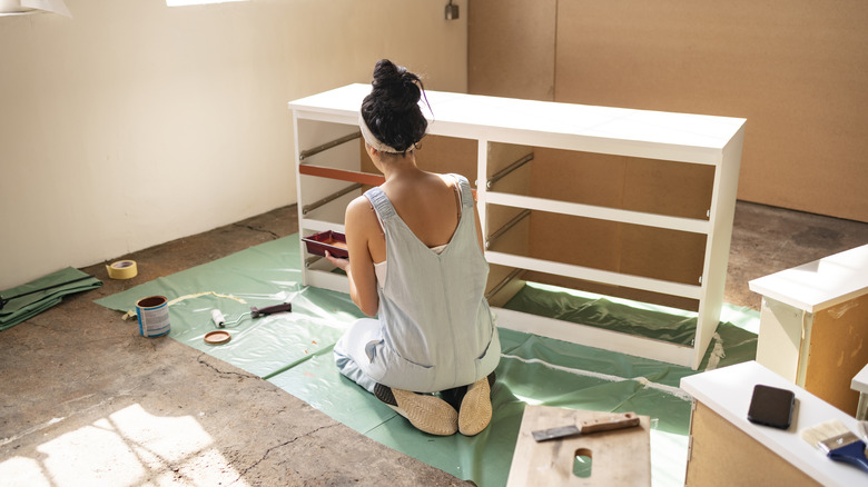 woman painting dresser diy project