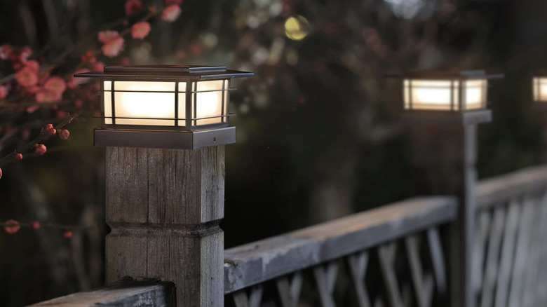 Stylish solar light caps on outdoor wooden fence