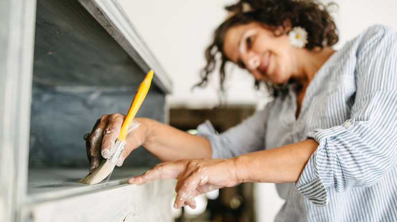 Woman painting sideboard