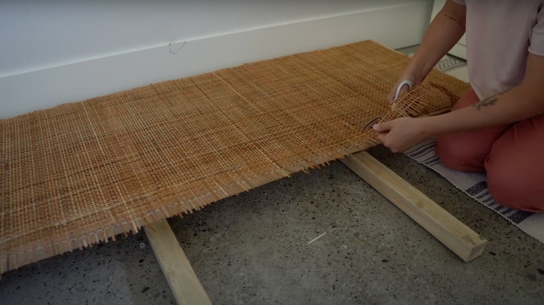 YouTuber trimming rattan from headboard