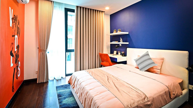 A color-blocked modern bedroom with red, white and blue walls