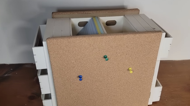 A white DIY desk organizer with a cork board on front and space to hold all your desk essentials