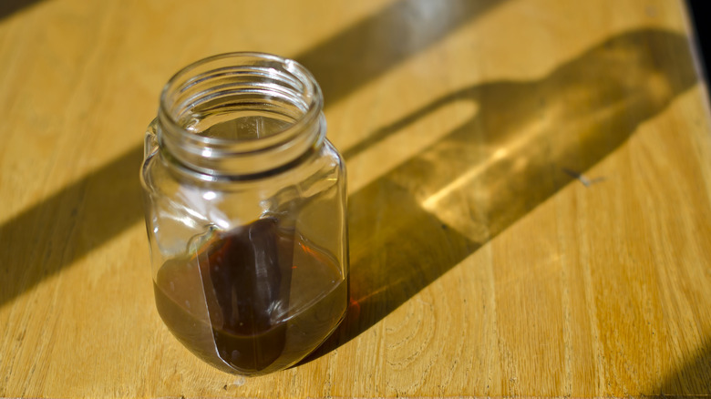 Glass jar with dark liquid