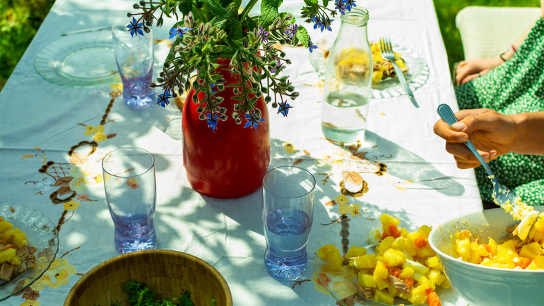 outdoor dining table setting with flowers in the center