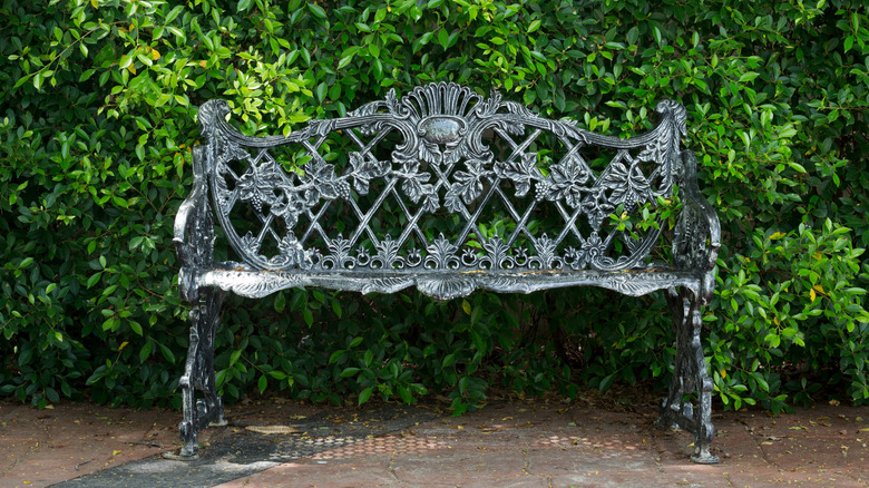 ornate black bench in garden