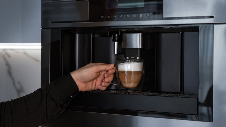 Person making drink in built-in coffee machine