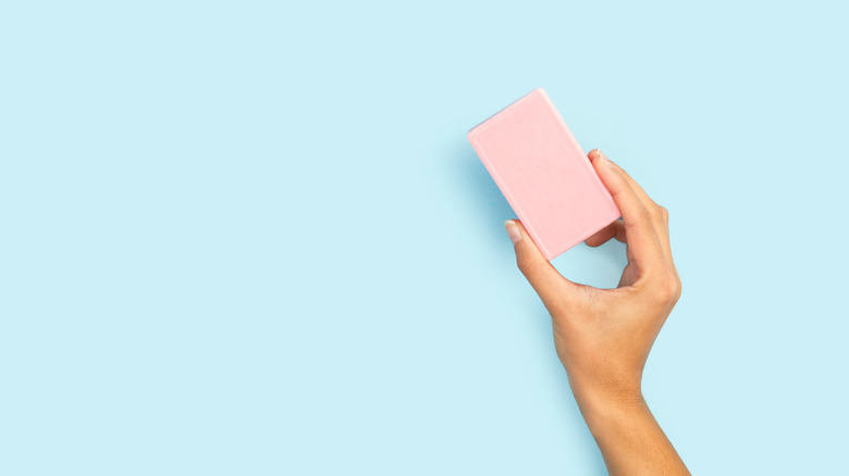 Woman holding bar of pink soap