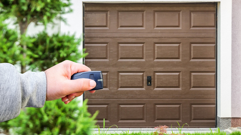 A person trying to open their garage door with the remote