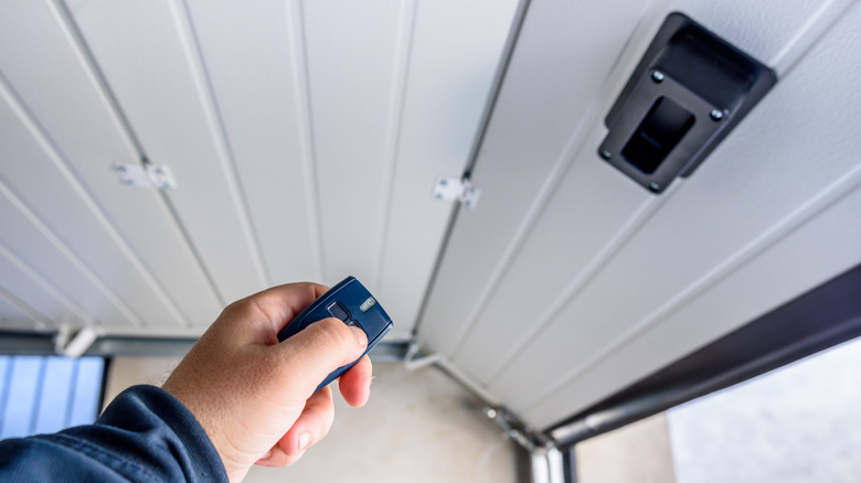 A person pointing their remote at the garage door