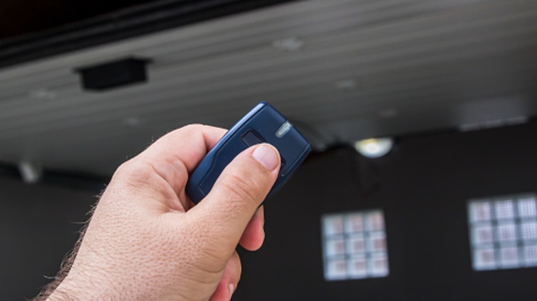 A person pushing the button their garage door remote