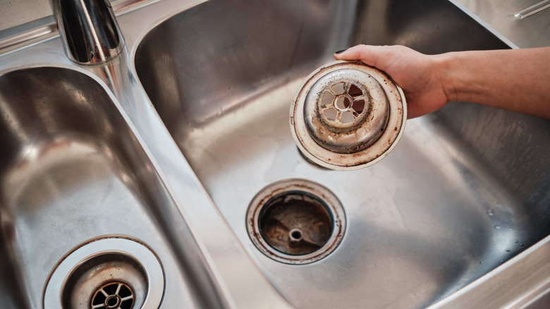 A stained kitchen sink and drain