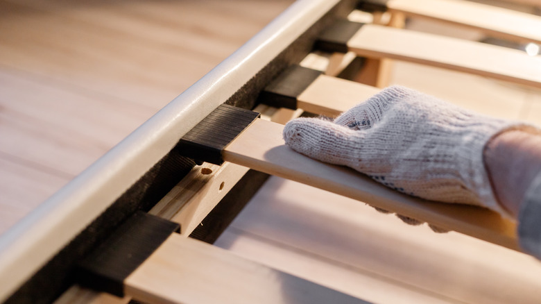 man touching a wood bed