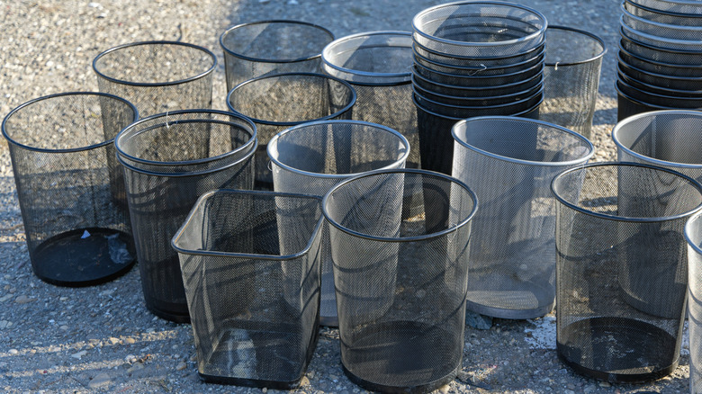 Stacks of metal wire bins outside on the ground