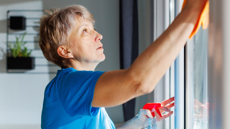 A woman cleans her windows before sealing them