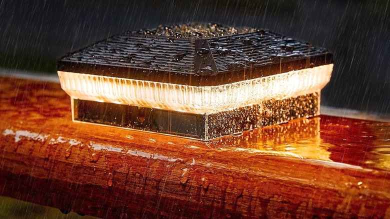 Three bright fence post caps light a wooden fenceline