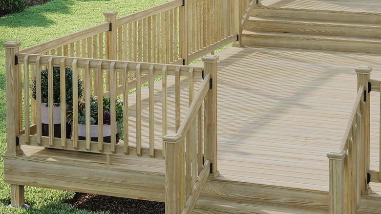 A tiered wooden deck is decorated with wooden fence post caps