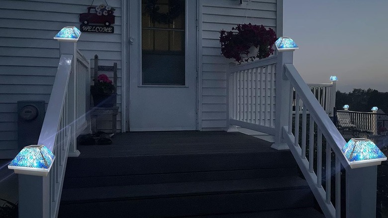 Mosaic solar powered fence post caps light an outdoor staircase