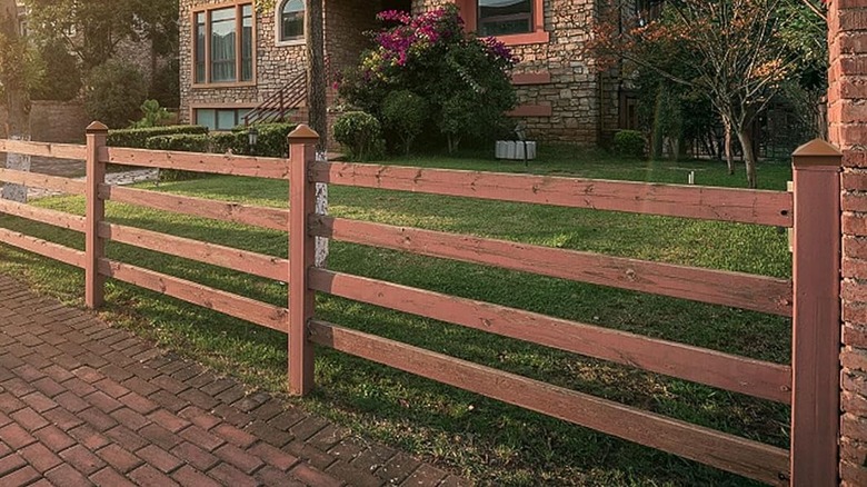 Brown pyramid fence post caps top a wooden fence