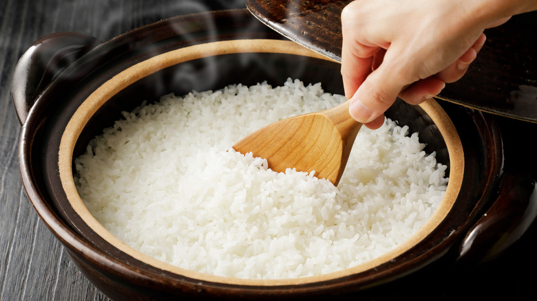 Person stirring pot of rice