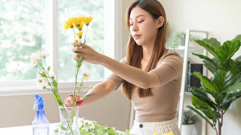 woman placing flowers in vase