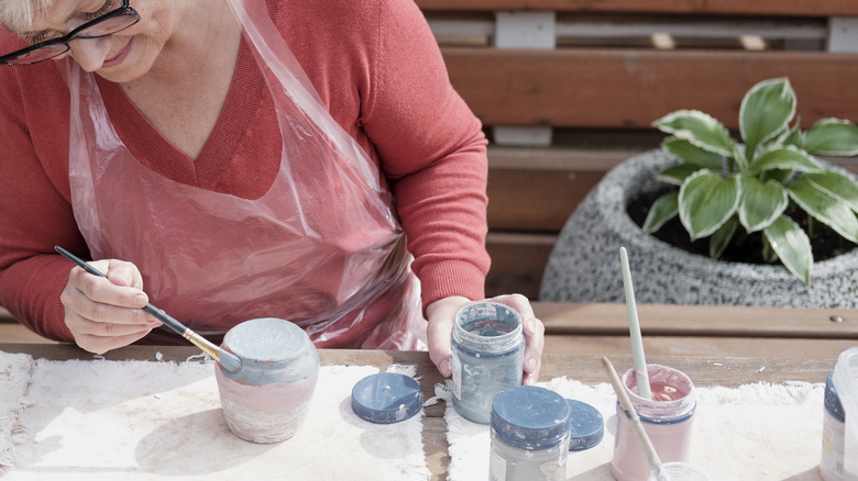 woman painting small vase