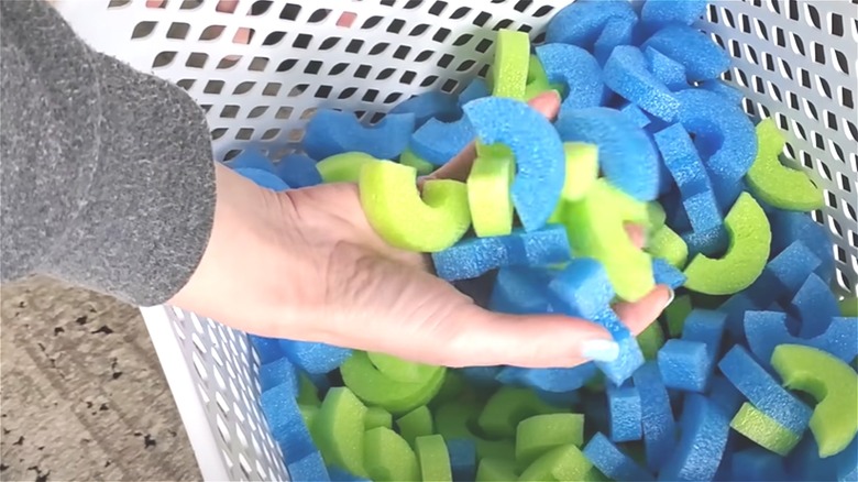 Woman holding pool noodles pieces