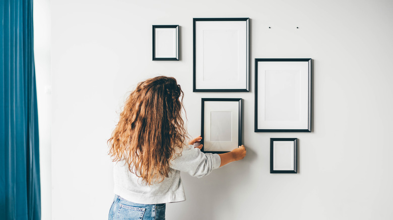 Woman creating gallery wall 