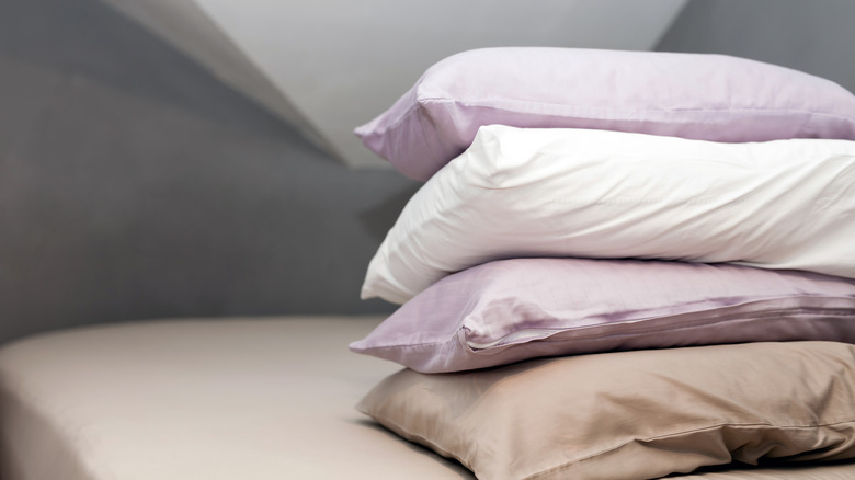 pile of pillows resting on bed