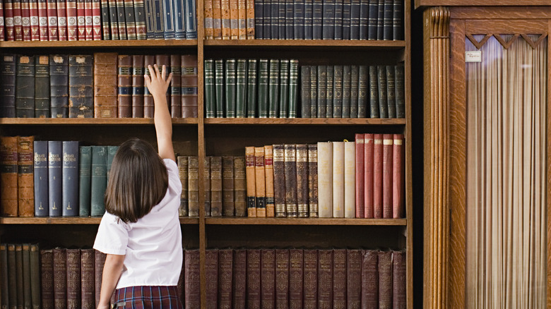 child reaches for library book