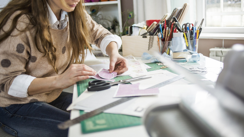 woman cutting paper on table