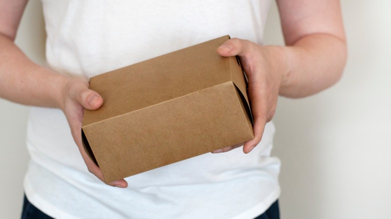 person holding small cardboard box