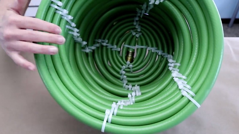 Coiled garden hose basket