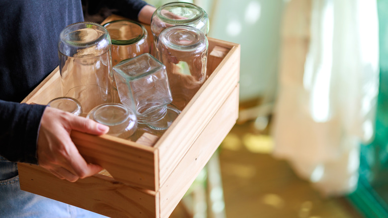 Person with box of empty jars