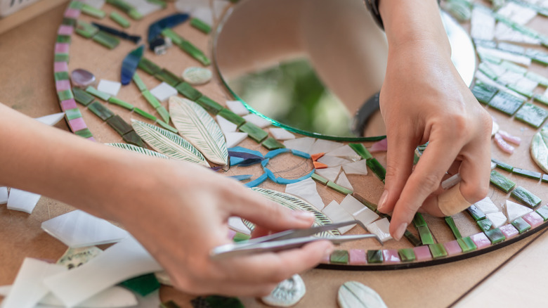 Someone making a mirror mosaic