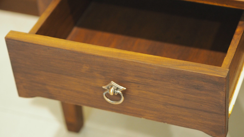 Wooden dresser drawer with decorative brass hardware