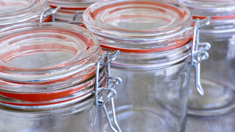 Closeup of empty glass jars with lids on countertop